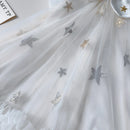 White fabric with star-shaped embellishments on a white background, Obroi