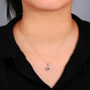 Silver necklace with a heart pendant worn by a person against a neutral background, Obroi