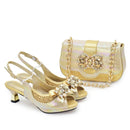Gold high-heeled shoes with embellishments and a matching handbag on a white background, Obroi