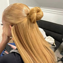 Woman with long blonde hair styled in a high bun, sitting in a salon chair, Obroi
