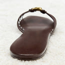 Brown sandal with a strap on a textured white surface, Obroi