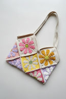 Crocheted bag with colorful flower patterns on a light gray background, Obroi