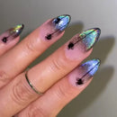 Obroi Nails with spider design and multicolored glitter on a neutral background