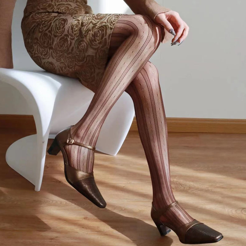 Person wearing patterned tights and high heels sitting on a white chair, Obroi