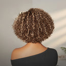 Person with curly hair wearing a black top against a neutral background, Obroi