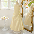 Yellow dress on a mannequin in front of a decorative mirror with floral arrangements, Obroi