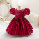 Red children's dress on a mannequin with decorative elements in a elegant setting, Obroi