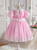 Pink dress on a mannequin against a decorative wall with flowers, Obroi