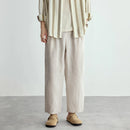 Person wearing a striped shirt and beige pants on a plain background, Obroi