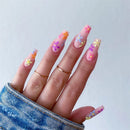 Hand with colorful floral nail design on a light gray background, Obroi