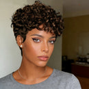 Woman with short, curly hair wearing a gray shirt indoors, Obroi