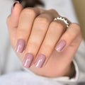 Close-up of a hand with pink nail polish on a blurred background, Obroi