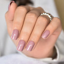 Close-up of a hand with pink nail polish on a blurred background, Obroi