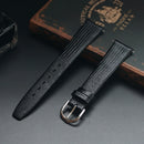 Black textured watch strap with silver buckle on a dark surface, Obroi