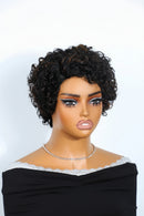 Short curly wig on a mannequin bust with a black off-the-shoulder top and a rhinestone necklace, photographed against a light gray background, Obroi