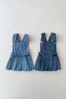 Two denim pinafore dresses on a light gray background, Obroi