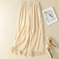 Beige lace-trimmed pants on a beige background with a photo frame and shoes, Obroi