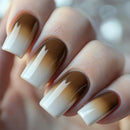 Nails with a gradient design transitioning from white to brown on a blurred background, Obroi