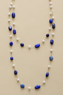 Necklace with blue beads and pearls on a beige background, Obroi