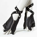 Black fingerless gloves with silver metal zippers, wrap-around straps, and silver grommets, displayed on a white mannequin foot and lower leg against a white studio background, Obroi