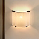 Obroi Wall-mounted light fixture with a white shade and black trim on a neutral wall.