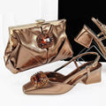 Gold clutch bag and shoes with decorative elements on a white background, featuring the brand 'Obroi'.
