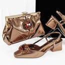 Gold clutch bag and shoes with decorative elements on a white background, featuring the brand 'Obroi'.