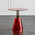 Round glass table with a red transparent base on a gray floor, Obroi
