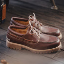 Brown leather shoes with white laces on a wooden surface, Obroi