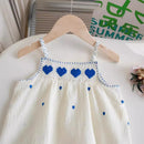 White dress with blue heart patterns on a hanger against a white background, Obroi