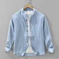Light blue denim shirt on a hanger against a gray background, Obroi