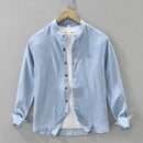 Light blue denim shirt on a hanger against a gray background, Obroi