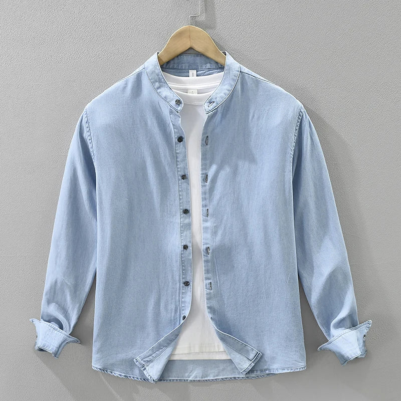 Light blue denim shirt on a hanger against a gray background, Obroi