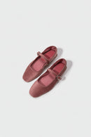 Pair of pink shoes with a strap on a light gray background, Obroi