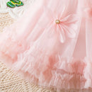 Close-up of a pink tulle skirt with a decorative bow on a textured surface, Obroi