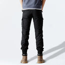 Person wearing black cargo pants on a white background, Obroi