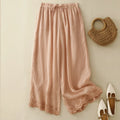 Pink pants with lace trim on a light beige background, accompanied by a woven bag and shoes, Obroi