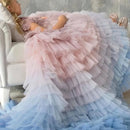 Woman in a pastel pink and blue layered dress sitting on a white couch, Obroi