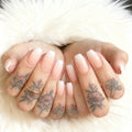 Close-up of hands with tattooed fingers and manicured nails on a soft white background, Obroi