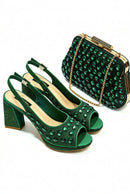 A matching green embellished women's outfit set featuring a pair of peep-toe slingback high heels and a structured clutch handbag with a gold chain strap, displayed on a clean white background, Obroi