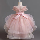 Pink children's dress with a large bow on a mannequin against a dark background, Obroi