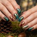 Close-up of hands with festive nail art featuring gold and red designs, set against a natural background with pine cones and acorns, Obroi