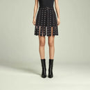 Person wearing a black patterned skirt with black boots on a light gray background, Obroi