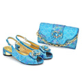 Blue glittery shoes and matching handbag with decorative elements on a white background, Obroi