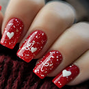 Close-up of red nail polish with white heart designs on a blurred background, Obroi