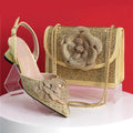 Gold high-heeled shoe and matching handbag with floral design on a red background, Obroi