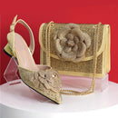 Gold high-heeled shoe and matching handbag with floral design on a red background, Obroi