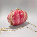 Pink and gold handbag with a chain strap on a light gray background, Obroi