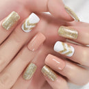 Hand with gold glitter and white chevron nail design on a neutral background, Obroi