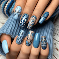 Nails with blue and beige floral patterns on a textured surface, Obroi